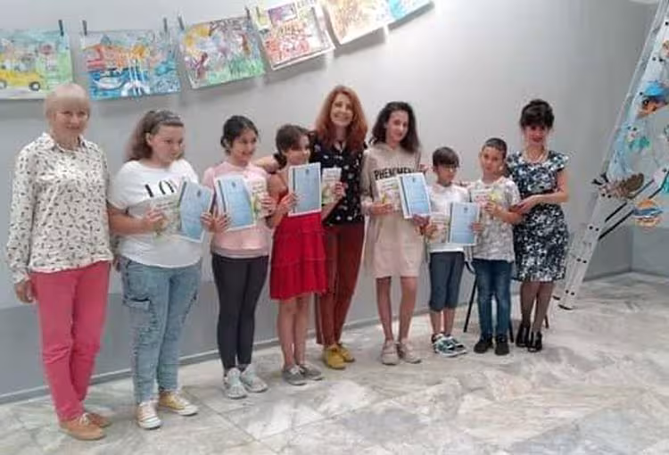Екипът на “Как се вари клоунска чорба”: Наталия Недялкова (превод и съставител), Роза Боянова (редактор) и Вили Колева (ръководител на Ателие за рисуване и приложни изкуства към читалище “Просвета – 1927”, гр. Бургас) с малките художници